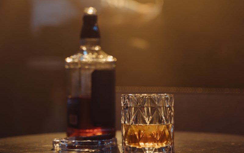 A cozy lounge scene with whiskey glass and blurred pianist, perfect for nightlife or bar themes.