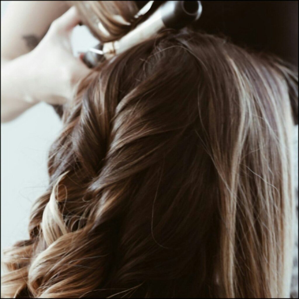 A woman getting her hair done by a hair stylist