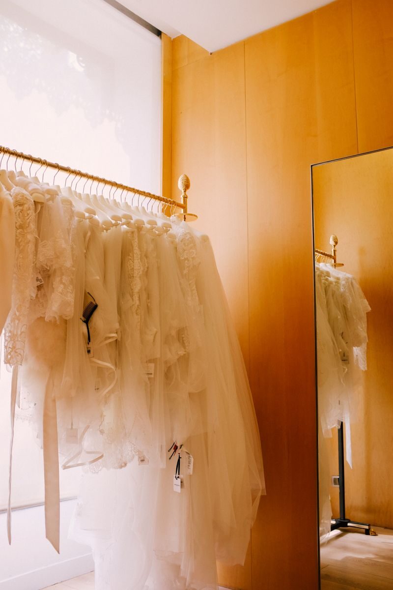 A collection of beautiful white bridal dresses showcased in a chic boutique setting.